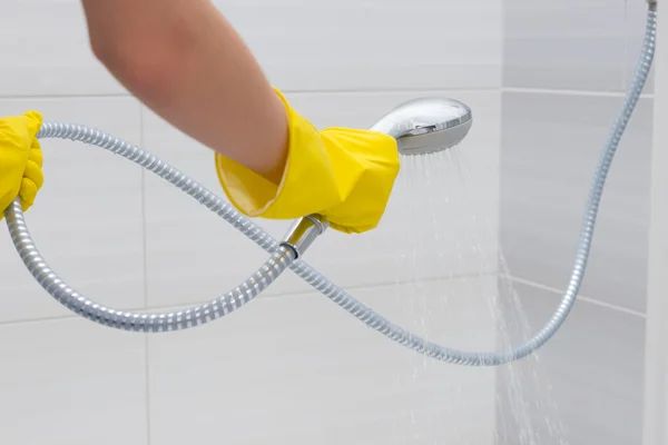 Gloved hands spraying with adjustable shower head