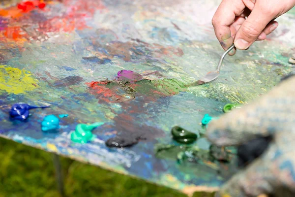 Painter Mixing Paint By Palette Knife