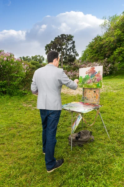 Lonely professional male artist working outdoors in the park