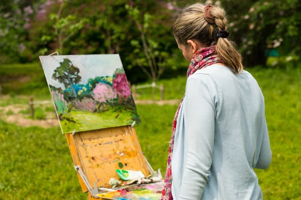 Female artist painting outdoors