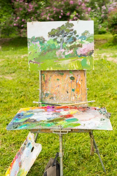 Artist\'s sketchbook with palette and picture in a garden