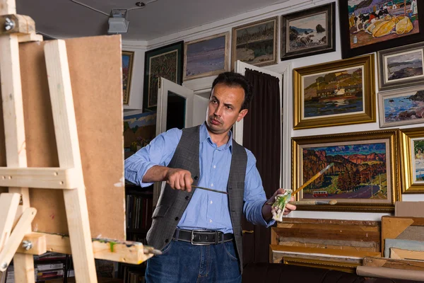Male painter evaluating his work