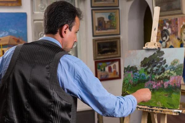 Painter working on an easel in a studio