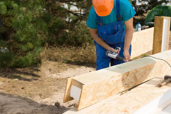 Construction worker drilling a beam