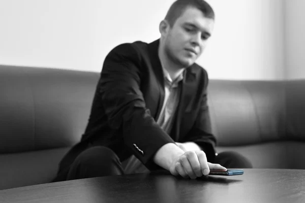 Male Executive Putting Phone on the Lounge Table