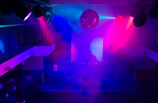 DJ in Night Club Lit with Colorful Lights