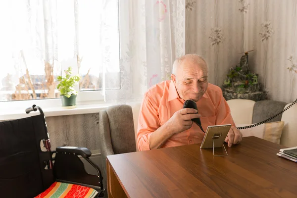 Old Man Cleaning his Beard with Razor at the Table