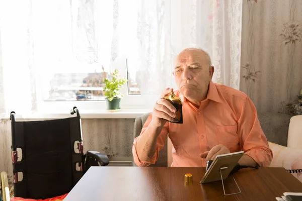 Sitting Old Man Holding Bottle Spray of Aftershave