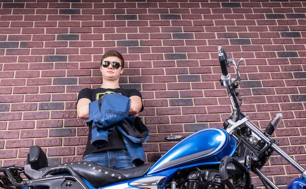 Young Man Holding his Jacket Behind his Motorbike