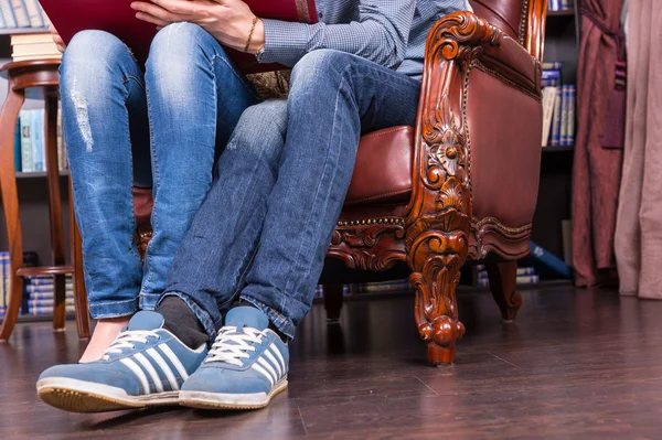 Legs and Feet of a Couple Sitting on One Chair