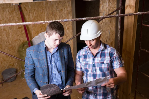 Architect and Foreman Inspecting Building Plans