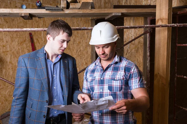 Architect and Foreman Inspecting Building Plans