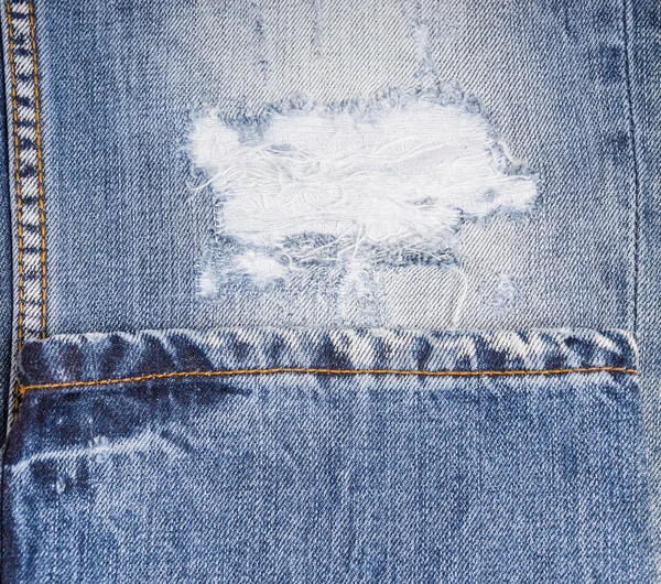 Detail of Frayed Rip in Faded Blue Jeans