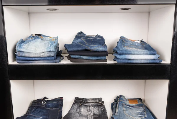 Stacks of Folded Blue Jeans on Shelf