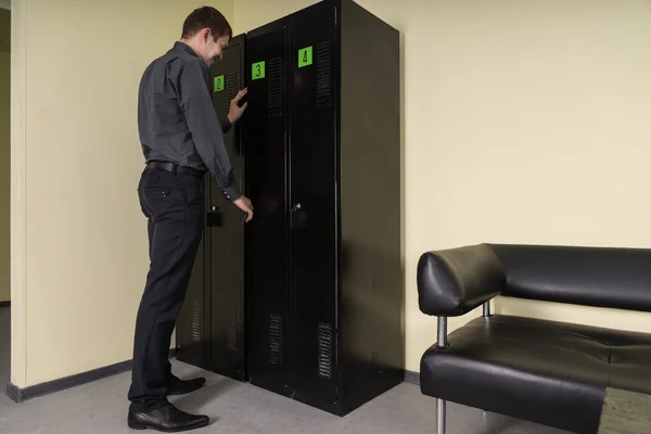 Man opening the door of a filing cabinet