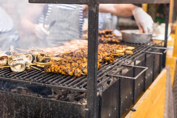 People Cooking Kebabs on Smoking Grill