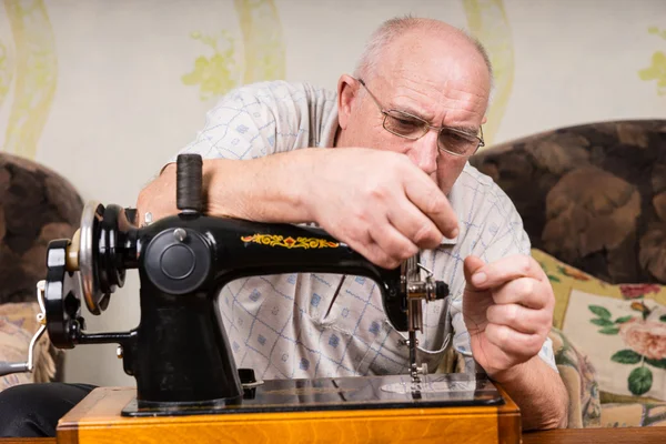 Senior man using a sewing machine