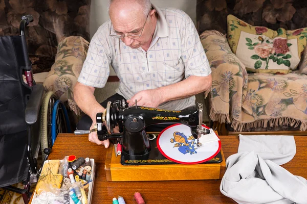 Senior Man Sewing Needle Point Craft with Machine
