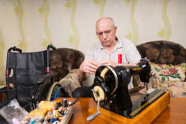Senior Man at Home with Vintage Sewing Machine