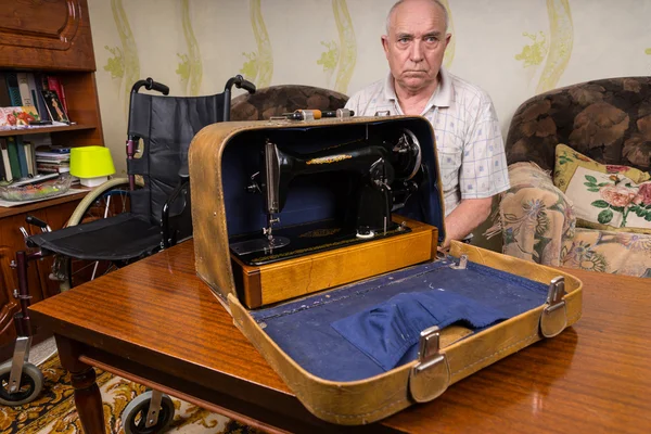 Senior Man Showing his Sewing Machine in a Case