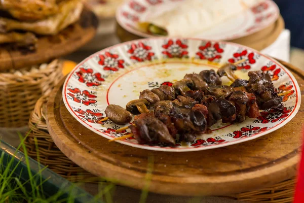 Grilled Kebabs on Patterned Plate on Table