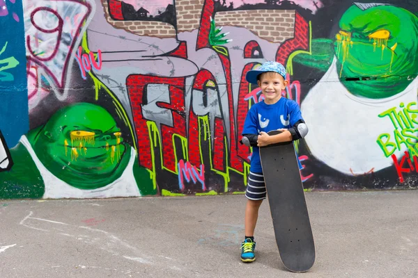 Small boy posing with his skateboard