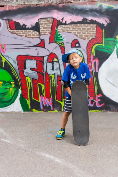 Young Boy with Skateboard in Urban Skate Park