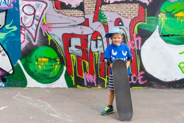 Boy Standing with Skateboard in Skate Park