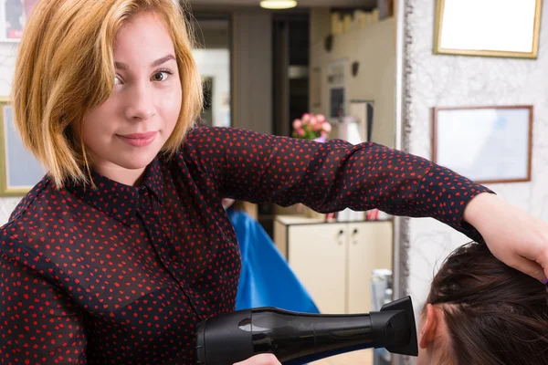 Blond Stylist Drying Hair of Woman with Blow Dryer
