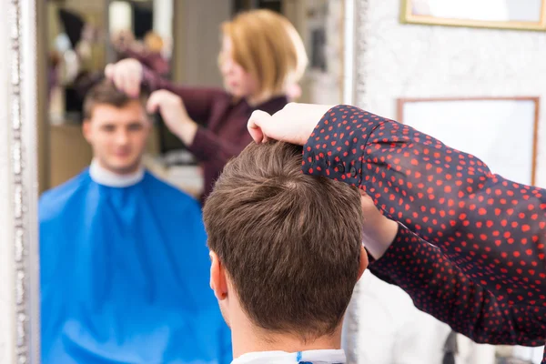 Young Man Having Hair Cut by Salon Stylist