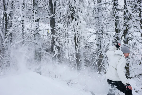 Young man snowboarding down a ski run