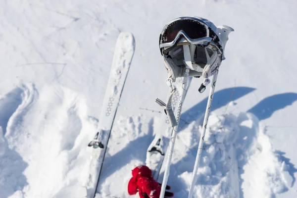 Helmet, Goggles, Poles and Skis on Snowy Hillside