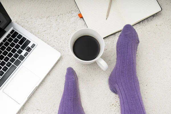 Shot of woman feet, laptop, coffee and notebook on the white car