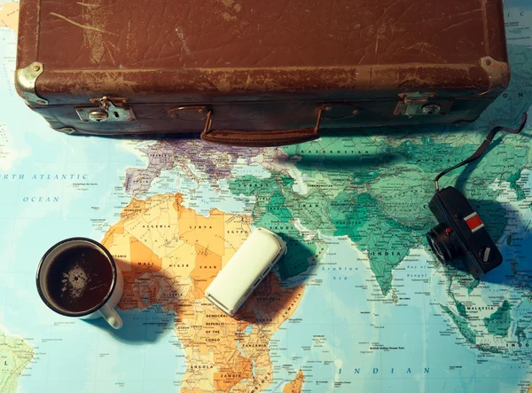 Travel planning concept with coffee cup and suitcase