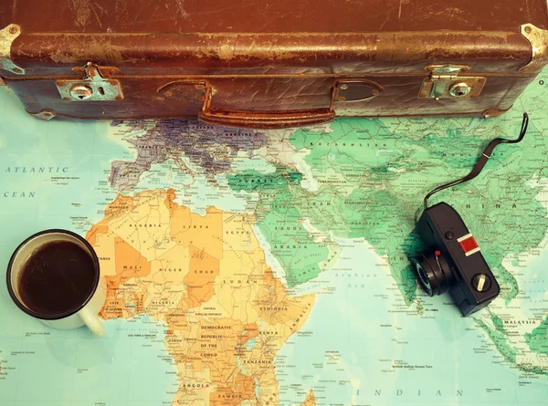 Travel planning concept with coffee cup and suitcase