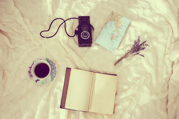 Cup of coffee, dry lavender, map, vintage notebook and camera ov