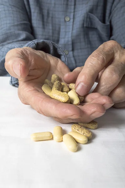 Senior hand sorting through a handful of medications