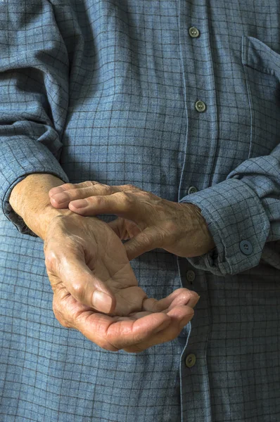 Elderly hand measuring her own arm pulse.