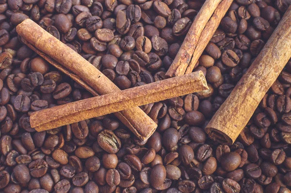 Close-up of cinnamon sticks on coffee beans.