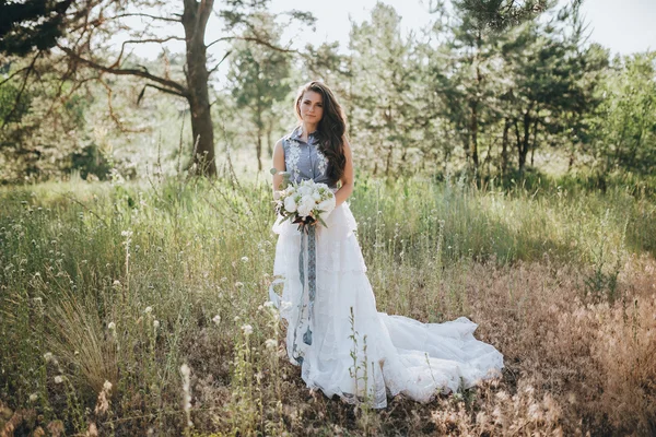 Woman in wedding dress in forest