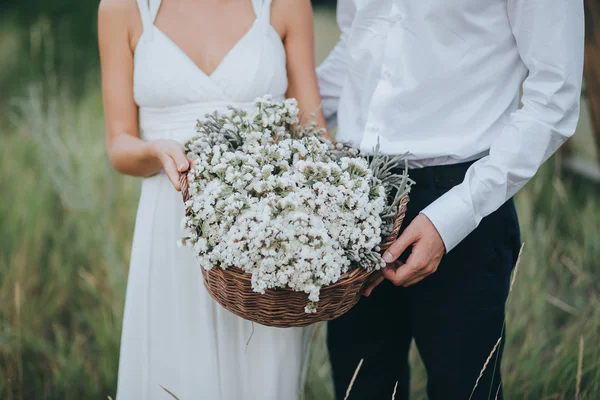 Guy and girl holding basket with flowers