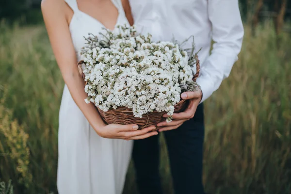 Guy and girl holding basket with flowers