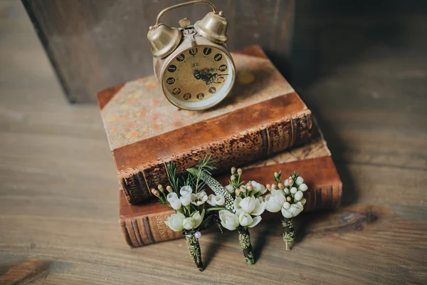 Old clock with books and flowers