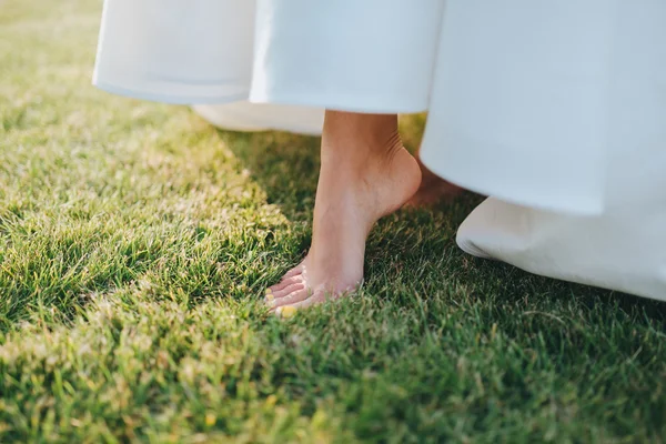 Foot of bride in white wedding dress