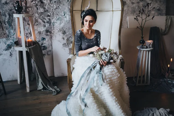 Beautiful bride in chair holding bouquet
