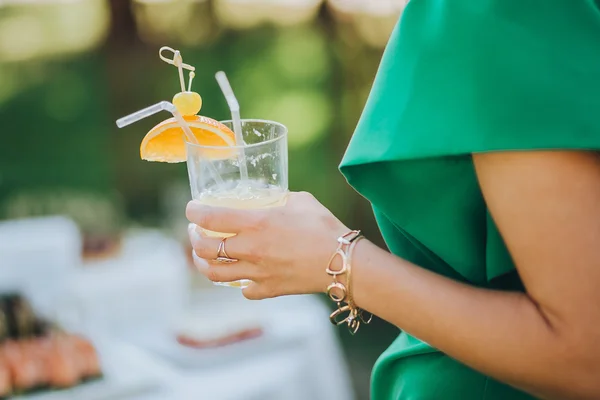 Girl in green dress holding cocktail