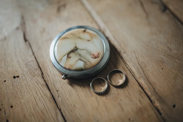 Wedding rings of the bride and groom lying on a wooden table