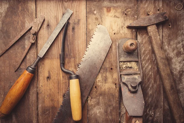 Od vintage hand tools on wooden background. Carpenter workplace.