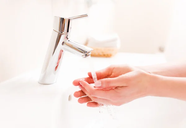 Woman washing your hands in bathroom