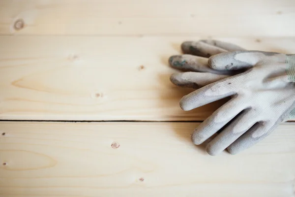 Close up of working gloves against wooden surface